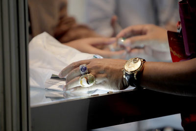 Midsection of man holding ice cream on table