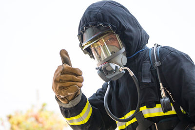 Portrait of man showing thumbs up while wearing protective workwear