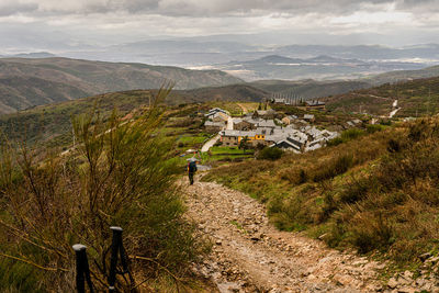 A peregrino walking along the path of the camino de santiago during a rainy day. december 2019