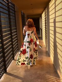 Sunlight falling on woman in dress walking through corridor