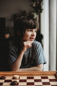 Portrait of boy looking through window