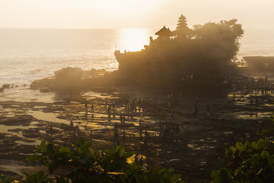 Scenic view of the sea temple tanah lot against sky during sunset