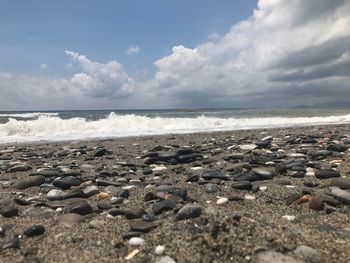 Pebbles on beach against sky