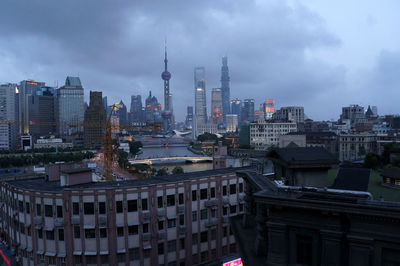 View of cityscape against cloudy sky