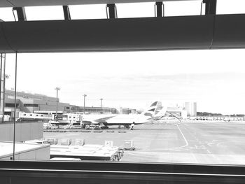 Airplane on airport runway against sky