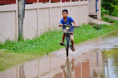 Full length of man riding bicycle on rainy season