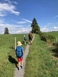 People walking on field against sky