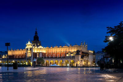 Illuminated historic building against blue sky at night