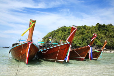 Boat moored on beach against sky