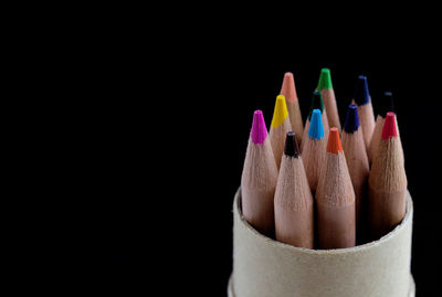 Close-up of colored pencils against black background