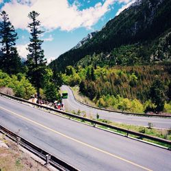 Roads against green mountains on sunny day