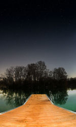 Scenic view of lake against clear sky at night