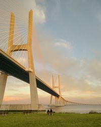 Bridge over sea against sky during sunset