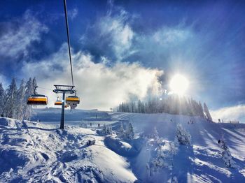 Ski lift against sky during winter