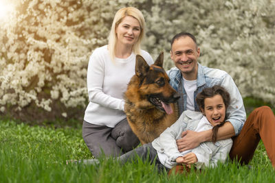 Portrait of happy family with dog at park