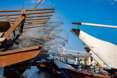 Fishing boats moored at port against sky