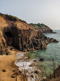 Rock formations on shore against clear sky