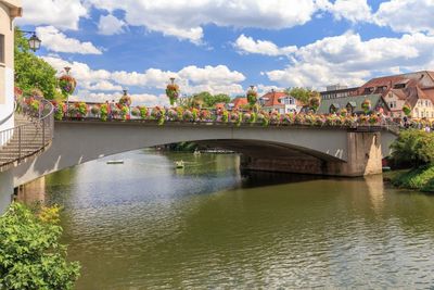 Arch bridge over river against sky