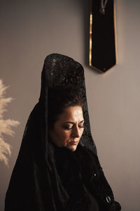 Portrait of woman standing against wall