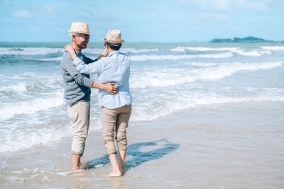 Happy couple dancing while standing at beach