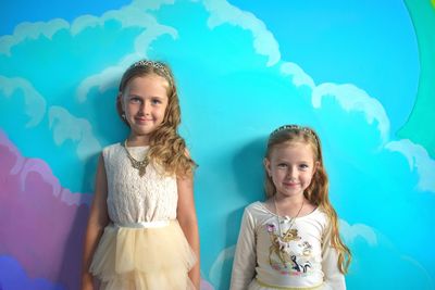 Portrait of smiling girl against blue background