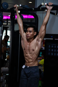 Young muscular man exercising in gym