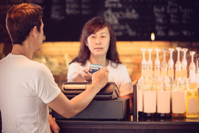 Close-up of young man paying with credit card