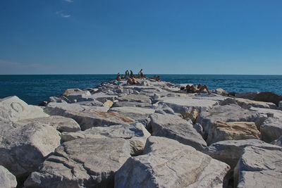 Rocks on beach against blue sky