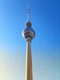 Low angle view of communications tower against blue sky