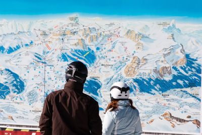 Rear view of people on snow covered mountain