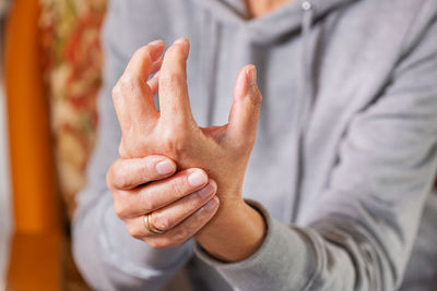 Senior woman suffering from hand and finger joint pain and inflammation. rheumatoid arthritis, gout.