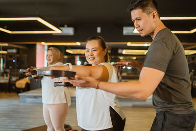 Portrait of young woman holding wineglass at gym