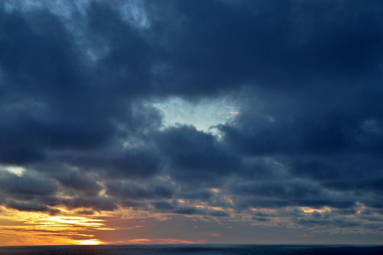 LOW ANGLE VIEW OF STORM CLOUDS AT SUNSET