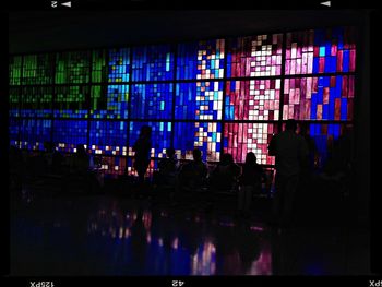 Reflection of illuminated people in puddle