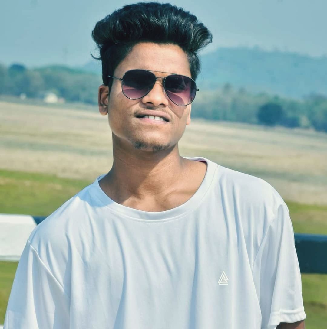 sunglasses, glasses, fashion, portrait, one person, young adult, adult, front view, casual clothing, men, blue, spring, person, day, nature, waist up, goggles, leisure activity, cool attitude, looking at camera, hairstyle, lifestyles, clothing, headshot, standing, outdoors, smiling, grass, focus on foreground, human face, emotion, t-shirt, summer, beard, happiness, eyewear, black hair, sports, sky, relaxation, cool, sunlight