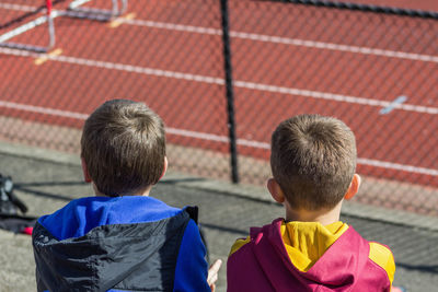 Rear view of boys looking at running track