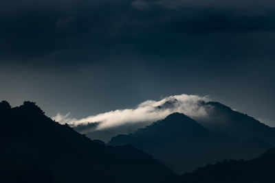 Low angle view of silhouette mountains against sky