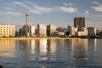 River by buildings against sky in city