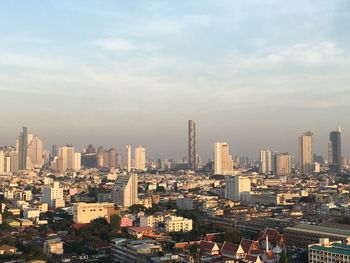 Aerial view of buildings in city against sky