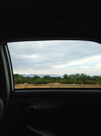 View of landscape seen through car window