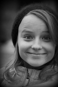 Close-up portrait of young woman smiling while wearing knit hat