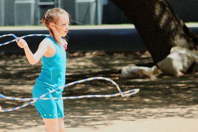 Side view of teenage girl rope jumping at playground