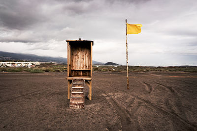 Wooden posts on field against sky