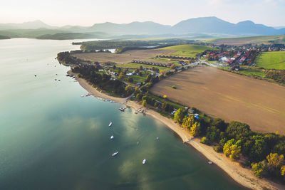 High angle view of sea and mountains against sky