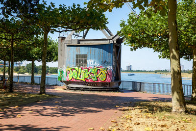 Graffiti on wall by sea against sky