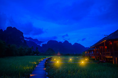 Scenic view of illuminated mountains against blue sky at dusk