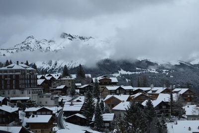 Snow covered houses and buildings against sky