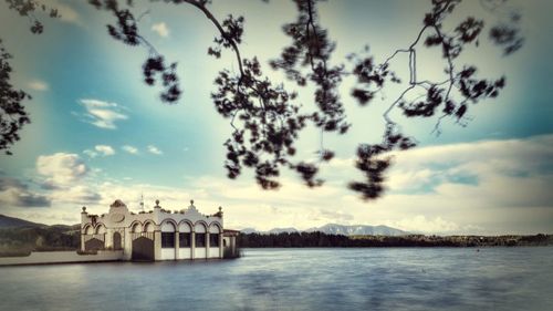 Building by river against sky