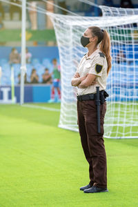 Side view of young woman standing on field