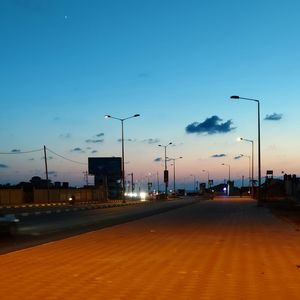 Street lights against sky at sunset